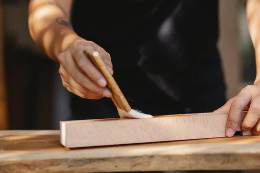 eine Person, die mit einem Messer ein Stück Holz schneidet