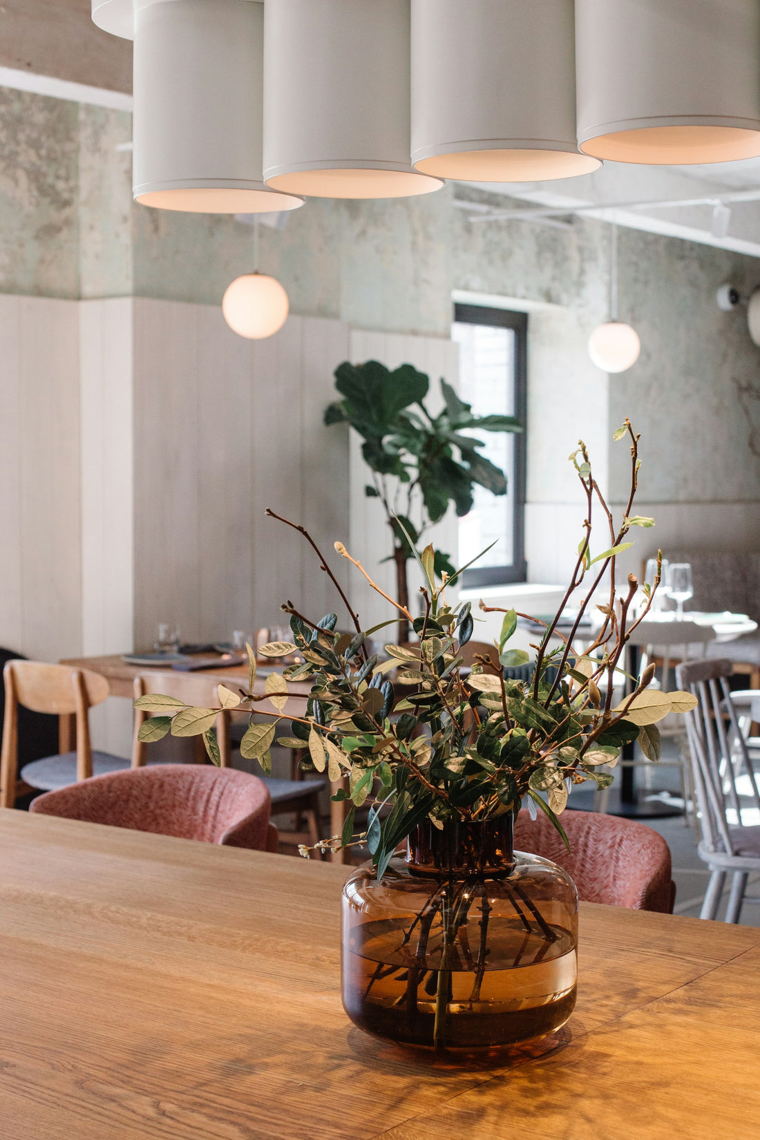 ein Holztisch, der mit einer Vase gefüllt mit Blumen bedeckt ist