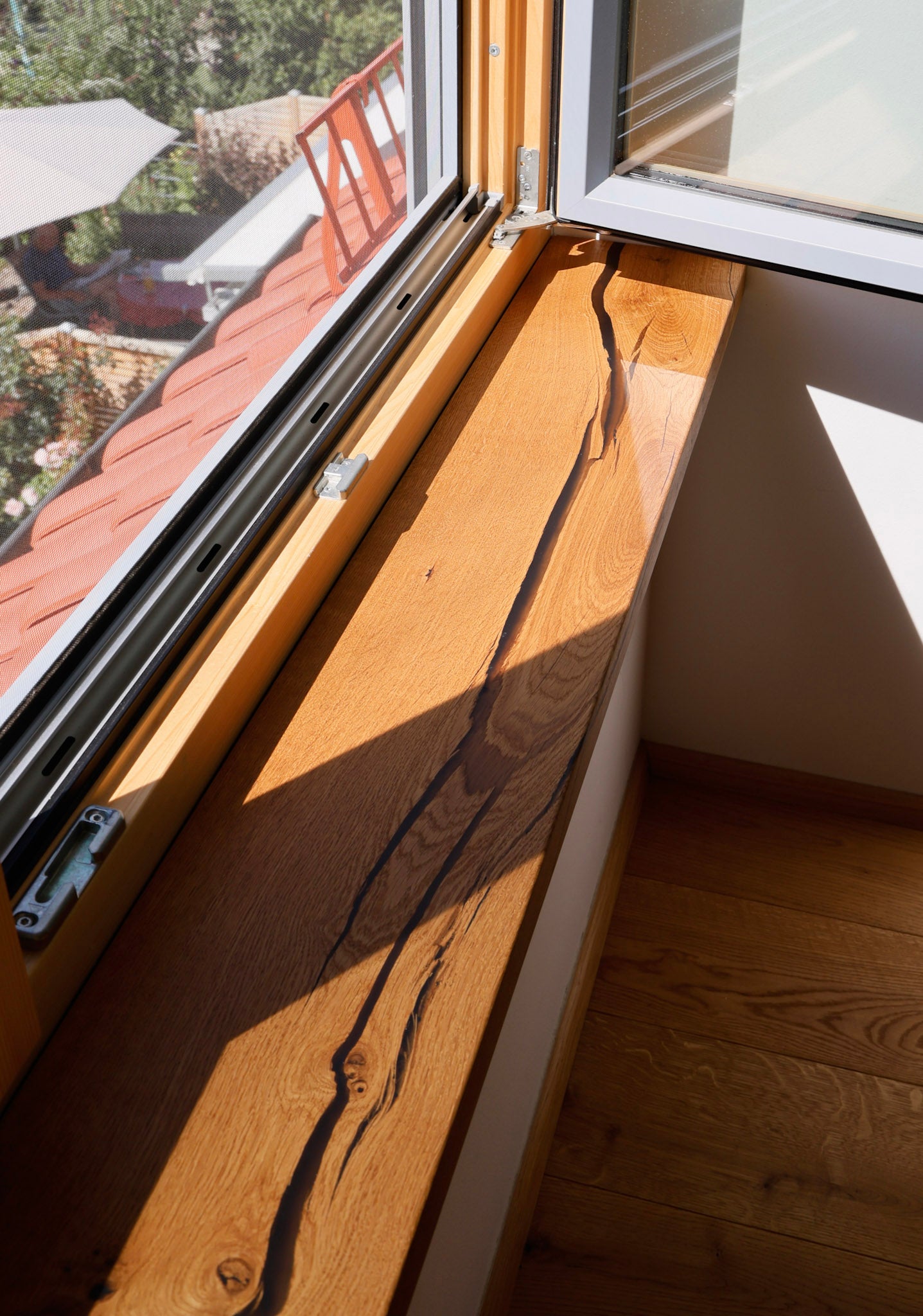 eine hölzerne Fensterbank mit Blick auf ein Haus